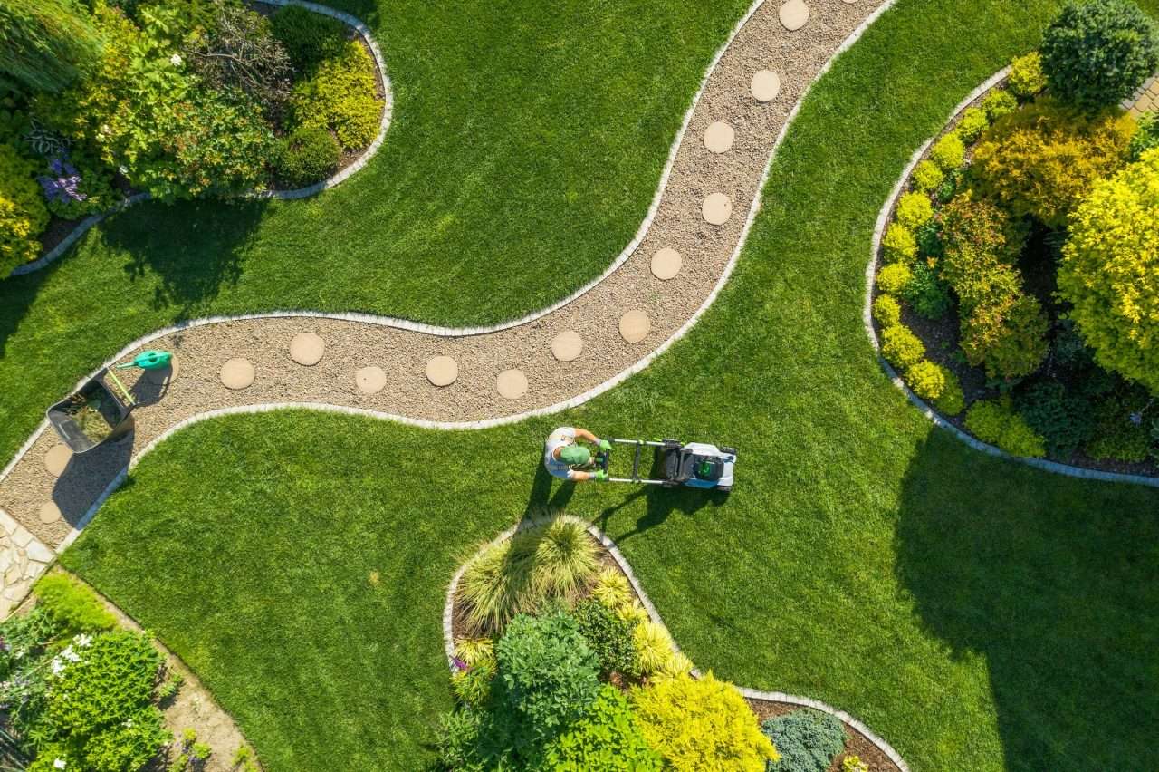 big garden grass field mowing by Caucasian gardener